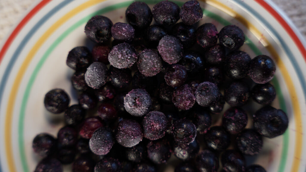 Zoomed-in photo of frozen blueberries to be included in muffin batter